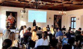 Vortragende vor Powerpoint, Teilnehmerinnen von hinten