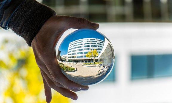 Das Gebäude der Technischen Wissenschaften am Campus Technikerstraße der Universität Innsbruck, gespiegelt in einer Kugel
