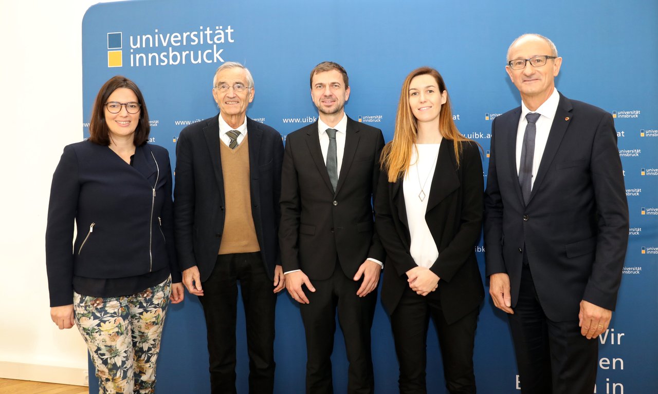 Fünf Personen stehen vor einer Pressewand.