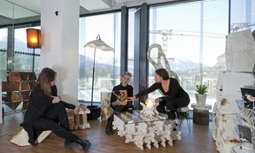 Drei Personen mit futuristisch anmutenden Möbeln.