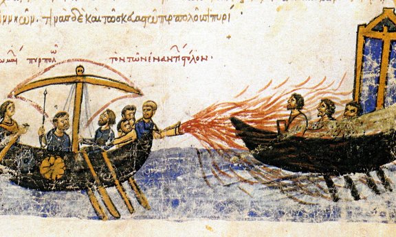 Das Griechische Feuer in einem Byzantinischen Manuskript: Abbildung zweier Boote mit 6 bzw. 3 Männern an Bord; Feuer wird durch eine Röhre auf das zweite Boot zurückgeschossen