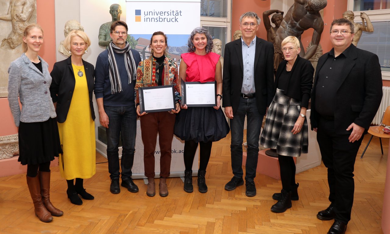 Gruppenfoto mit acht Personen, zwei davon halten eine Urkunde.