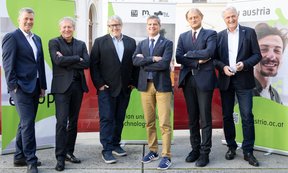 Mehrere Personen stehen in einer Reihe und blicken in die Kamera