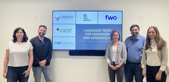Eva Konrad, Bart Deygers, Viktoria Ebner, Benjamin Kremmel and Laura Schildt in front of screen with project title and funding agencies on slide
