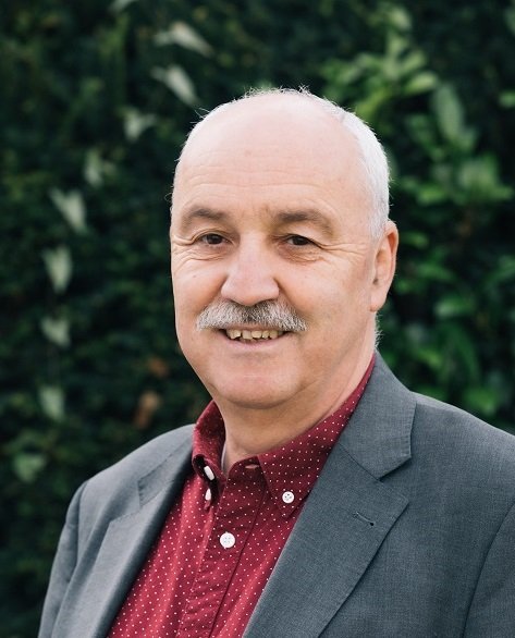Porträtfoto von Wolfgang Palaver mit rotem Hemd und grauem Sakko