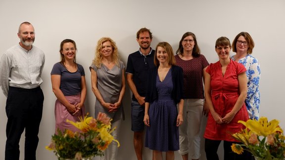 Group photos of the FSP coordinators, in front of a white wall and with flowers in the foreground.