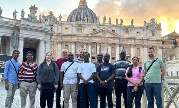 Menschen posieren für ein Gruppenfoto vor einer Sehenswürdigkeit in Rom
