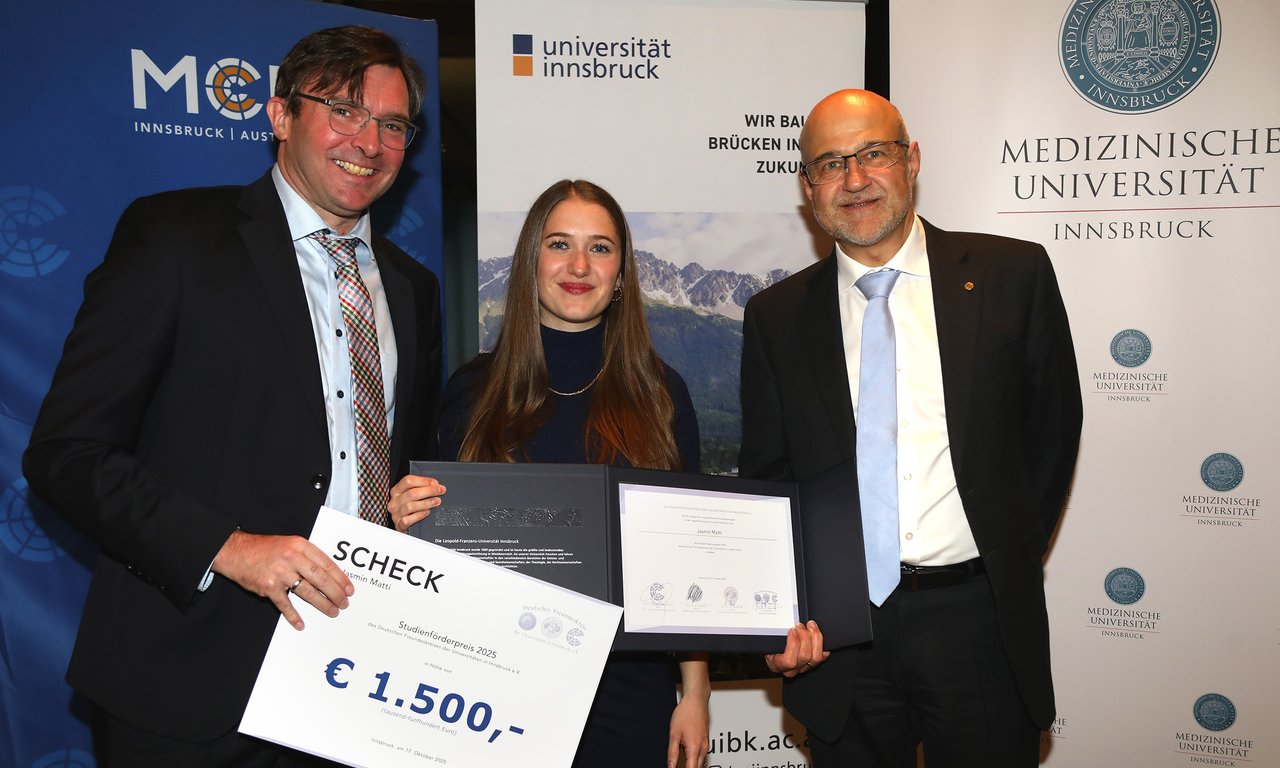 Drei Personen mit Urkunde