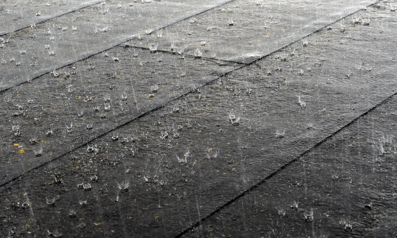 Raindrops patter on the cobblestones