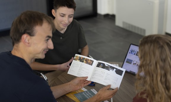 Students looking at a booklet on programs of study
