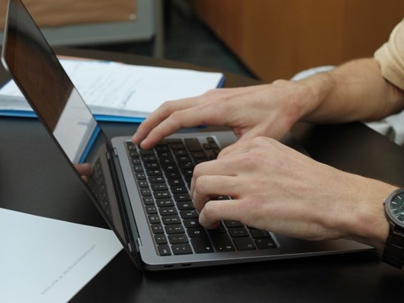 Person tippt auf Laptop