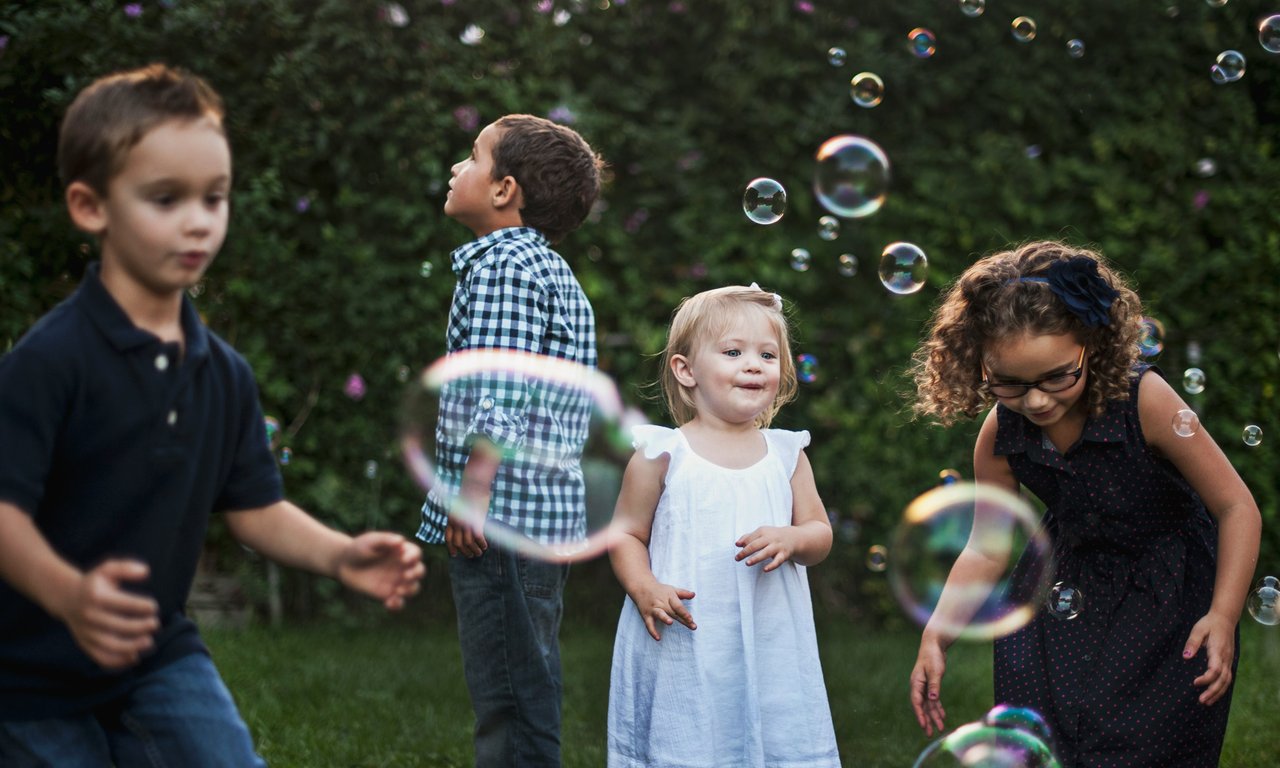 Kinder spielen mit Seifenblasen