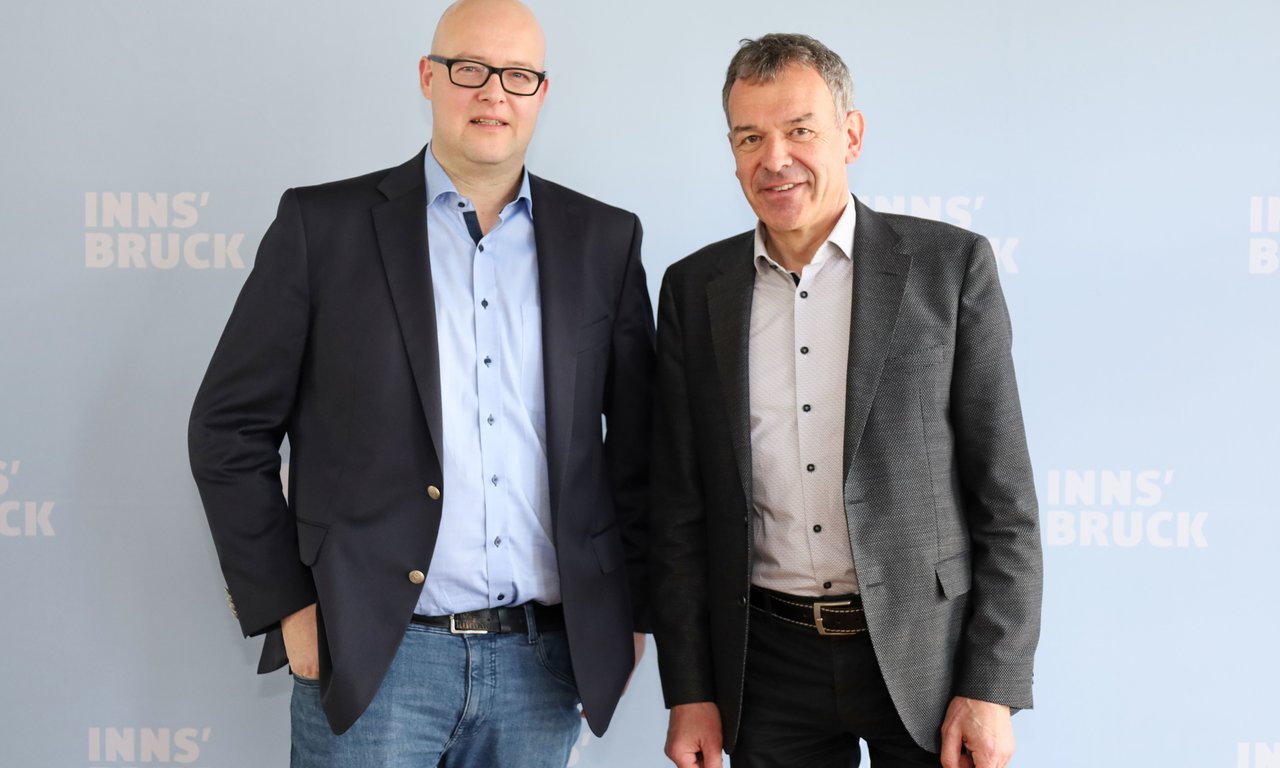Zwei Personen blicken in die Kamera