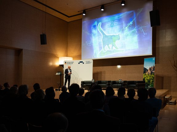 Foto von Gregor Weihs auf der Bühne und Publikum