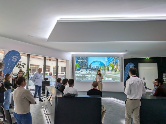 zeigt die teilnehmer:innen von hinten und vorne Vortragende