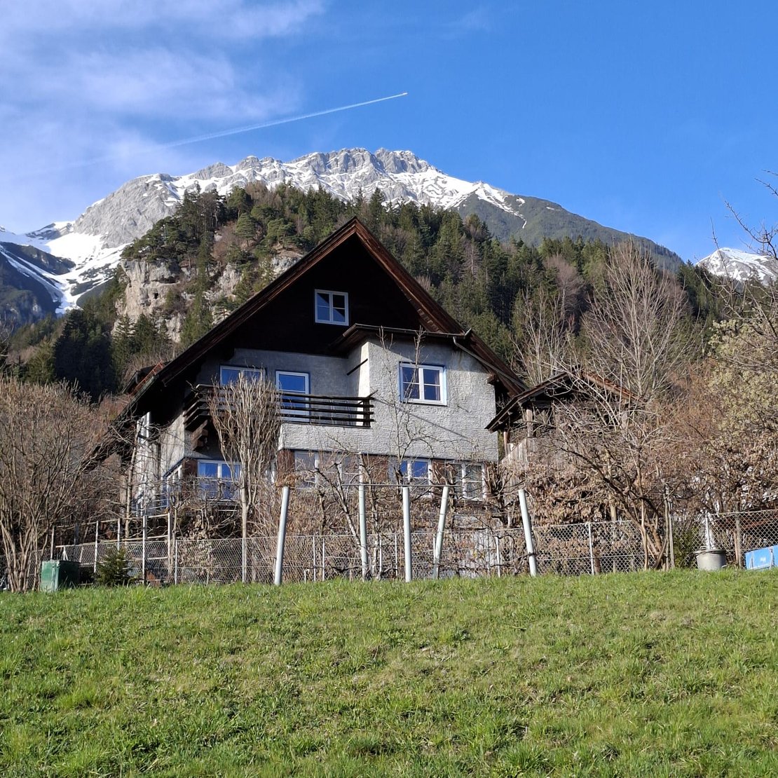 Altes Wohnhaus vor schneebedeckter Bergkulisse