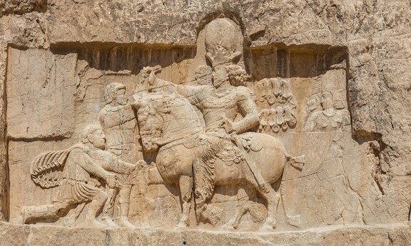 Relief von Šapur I. bei Naqsch-e Rostam, Iran: Das berühmte Relief zeigt Šapur I., wie er den römischen Kaiser Valerian gefangen nimmt. Kniend am Boden ist Philippus Arabs als Bittsteller, während der sasanidische König hoch zu Rosse sitzt.