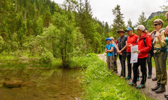 Gruppe schaut auf ein flaches Gewässer in den Bergen