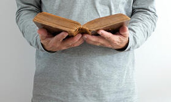 Mann öffnet eine Bibel