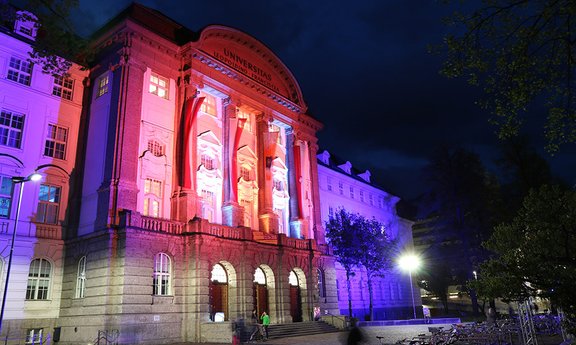 Hauptgebäude bei Nacht, blau-rot angestrahlt