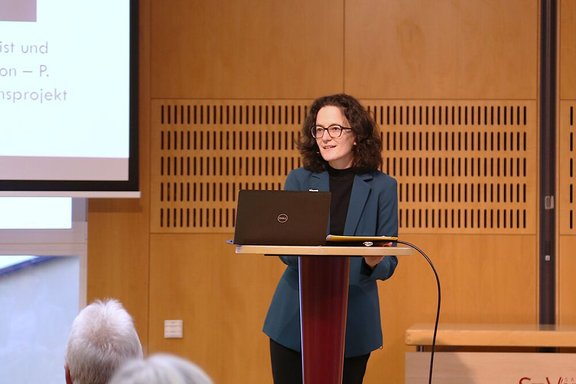 Zu sehen ist Michaela Quast-Neulinger. Sie steht an einem Pult und hält einen Vortrag.