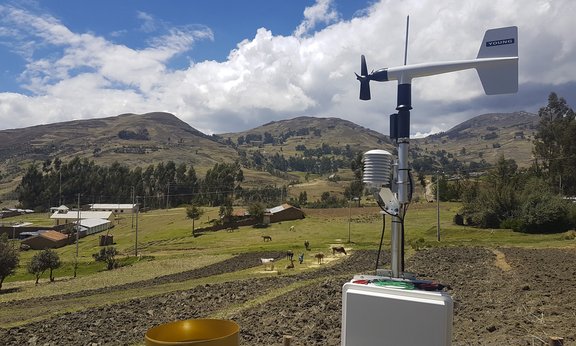 A weather station in front of a field in the Andes