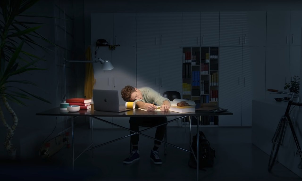 Eine Person mit dem Kopf auf dem Schreibtisch liegend