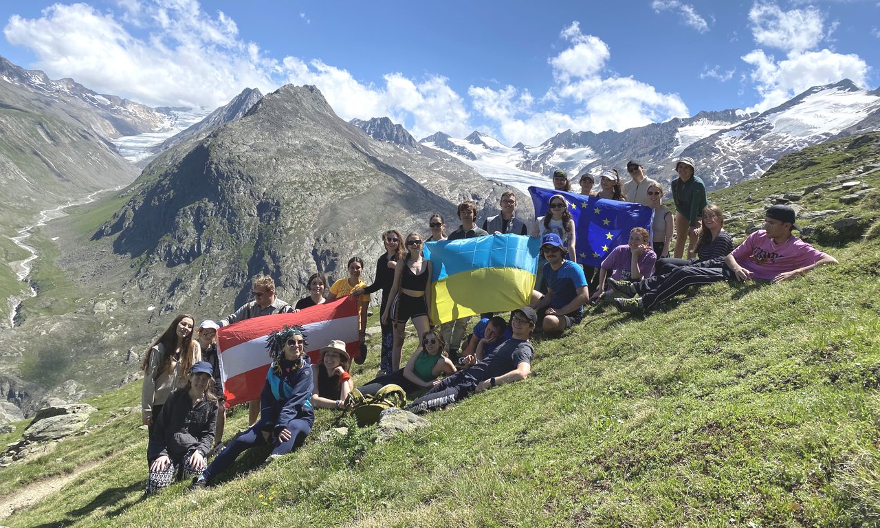 Gruppenfoto mehrerer Personen auf einer Almfläche in Obergurgl, Berge im Hintergrund.