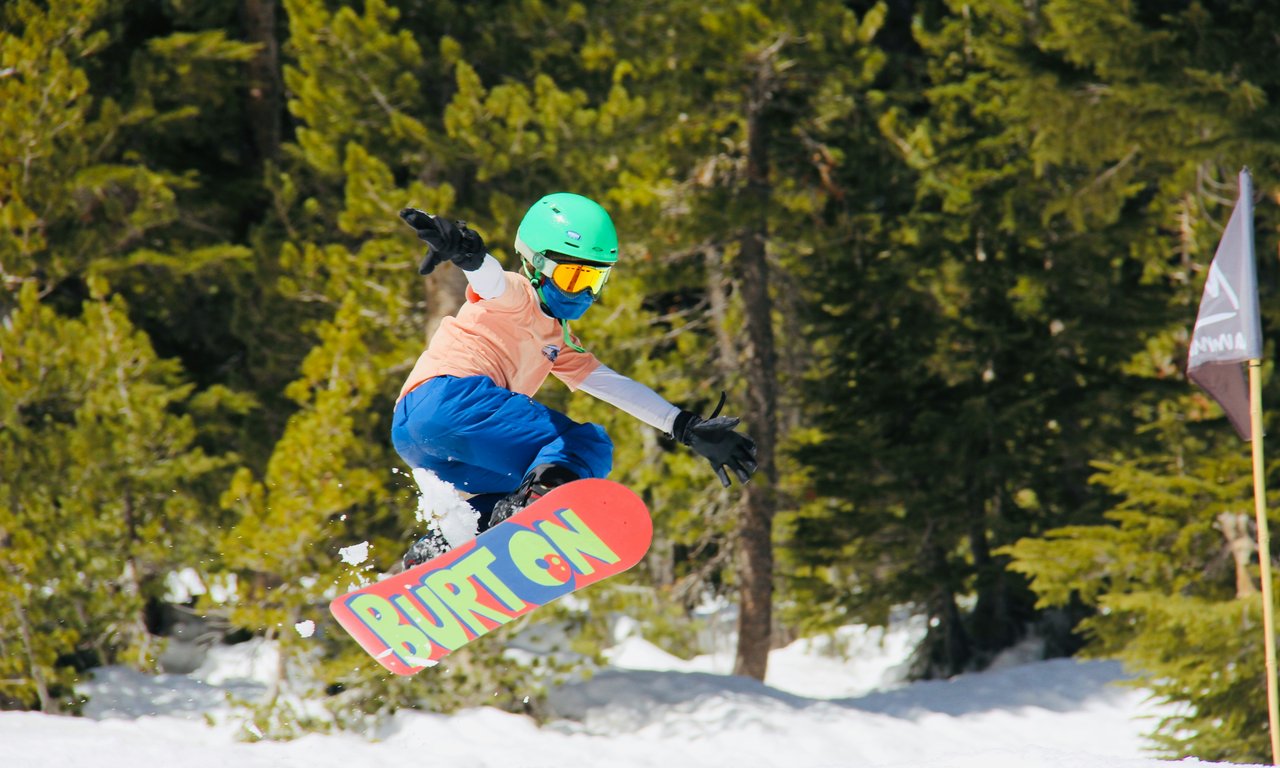 Mädchen zeigt Snowboard-Freeriding-Trick