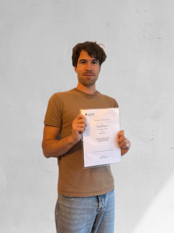 Portrait photo of Dominik Scherer with a certificate in hand