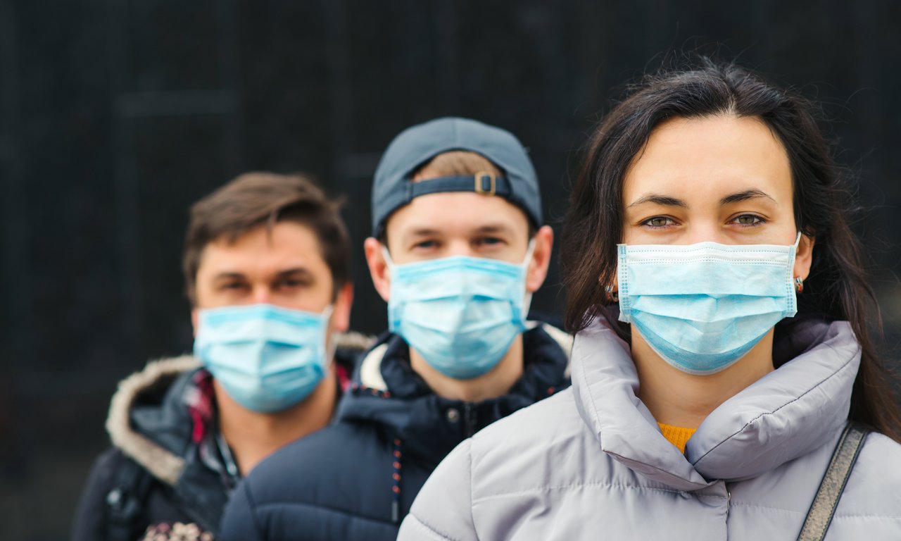 Drei Personen mit Masken vor Mund und Nase