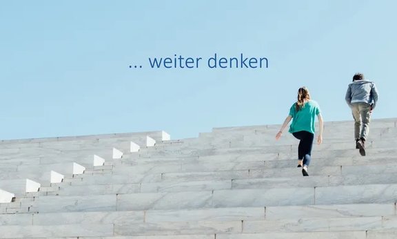 Drei Personen schreiten über Stiegen nach oben