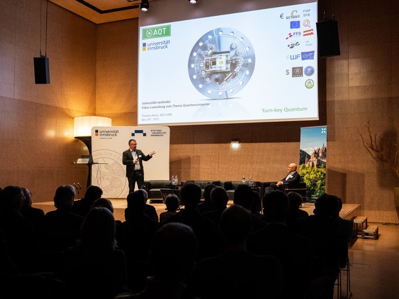 Foto von Thomas Monz auf der Bühne und Publikum