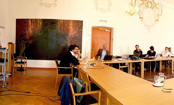 Personen sitzen in einem großen Besprechungsraum