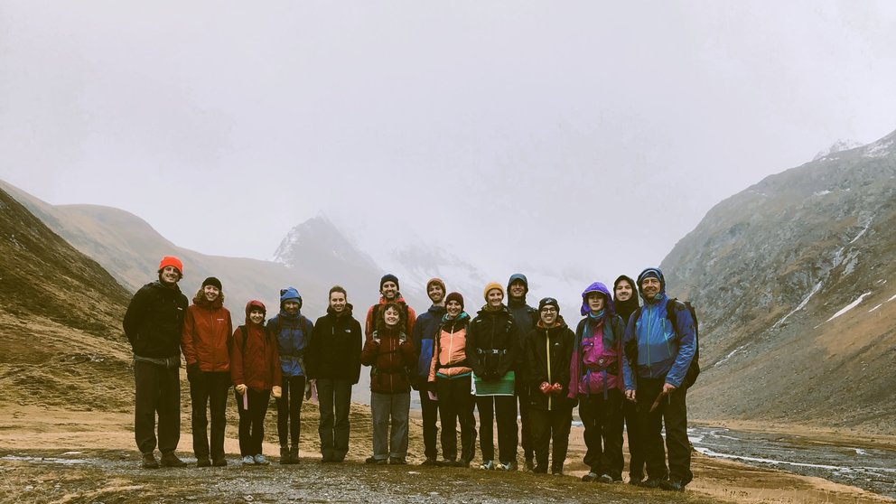 Exkursionsgruppe in einem vernebelten Tal