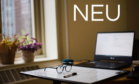 Zu sehen ist ein Schreibtisch mit einem Laptop, einem Whiteboard und einer Brille darauf.