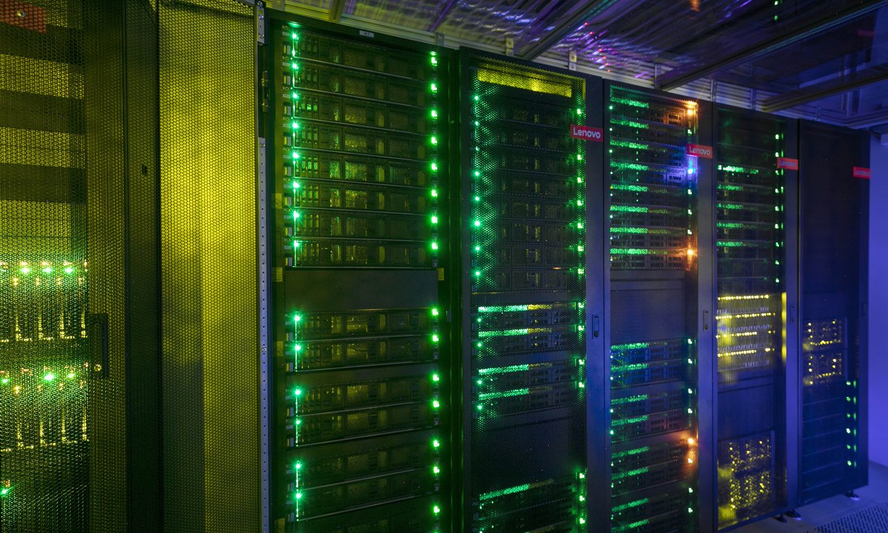 Nahaufnahme eines Supercomputers, man sieht blinkende Server-Racks.