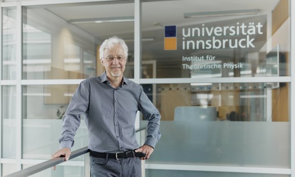 Hans Briegel steht vor dem Eingang des Instituts für Theoretische Physik