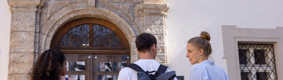 Studierende vor dem Eingang des Theologiegebäudes