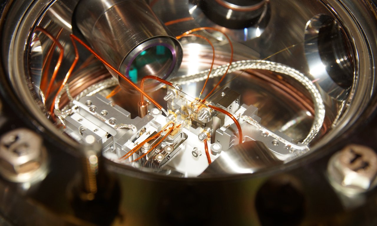 Experimenteller Aufbau mit Vakuumkammer im Zentrum.