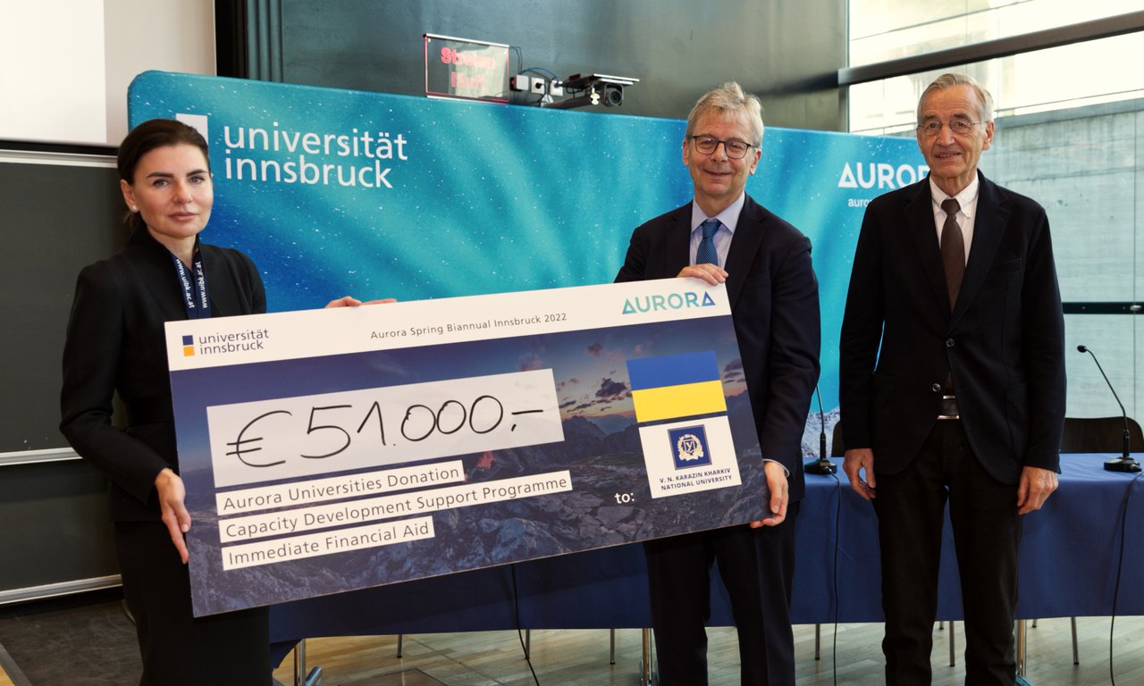 AURORA-Präsident Jón Atli Benediktsson (mi.) und Rektor Tilmann Märk (re.) überreichen die Spende der AURORA-Universitäten an Tetyana Kaganovska, Rektorin der Universität Charkiw (li.)