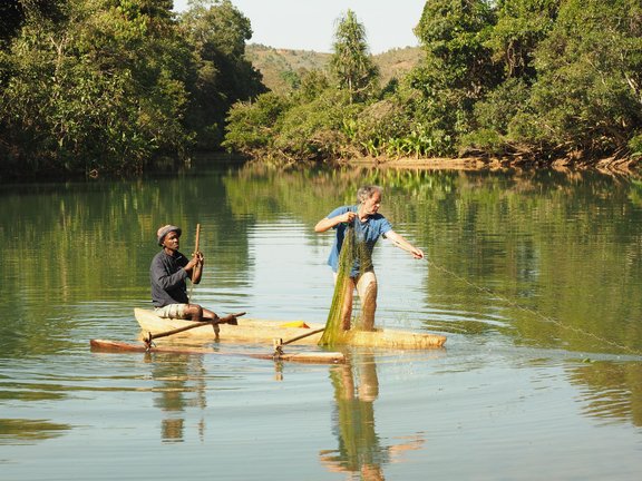 Zwei Menschen die mit einem Netz in einem kleinen See fischen