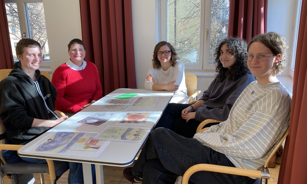 Zu sehen sind Teilnehmer:innen des Theotags. Sie sitzen an einem Tisch.