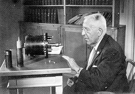 Auf dem Tisch ein Strahlungsapparat (nach Kolhörster), wie er in der Zeit von 1927 bis 1931 von Hess u. Mitarbeitern in Graz, auf dem Sonnblick und in Innsbruck verwendet wurde. Daneben eine Zarnboni-Säule zur Aufladung des Elektrometer-Systems.