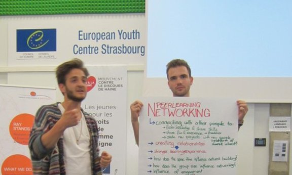 Junge Menschen präsentieren Ideen am Flipchart