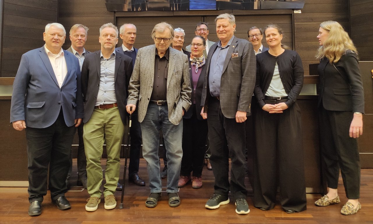 Zahlreiche Personen vor einer metallische glitzernden Installtion