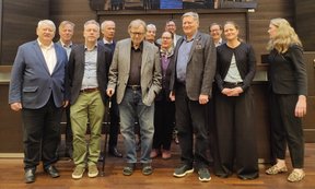 Zahlreiche Personen vor einer metallische glitzernden Installtion