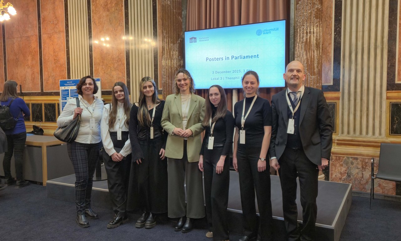 Gruppenfoto vor einem Bildschirm im Parlament