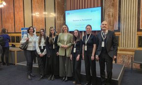 Gruppenfoto vor einem Bildschirm im Parlament