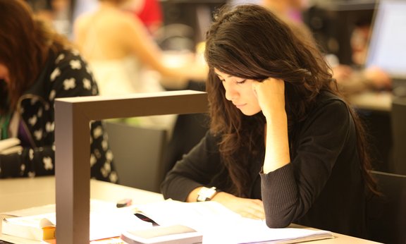 Studentin am Lesepult in der Universitätsbibliothek